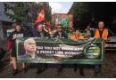 RMT members march, holding a banner that states "Do you know what a picket line is" alongside a photo of RMT General Secretary Mick Lynch